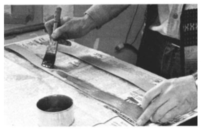 Jere applies glue to both sides of the veneer strips with a brush.